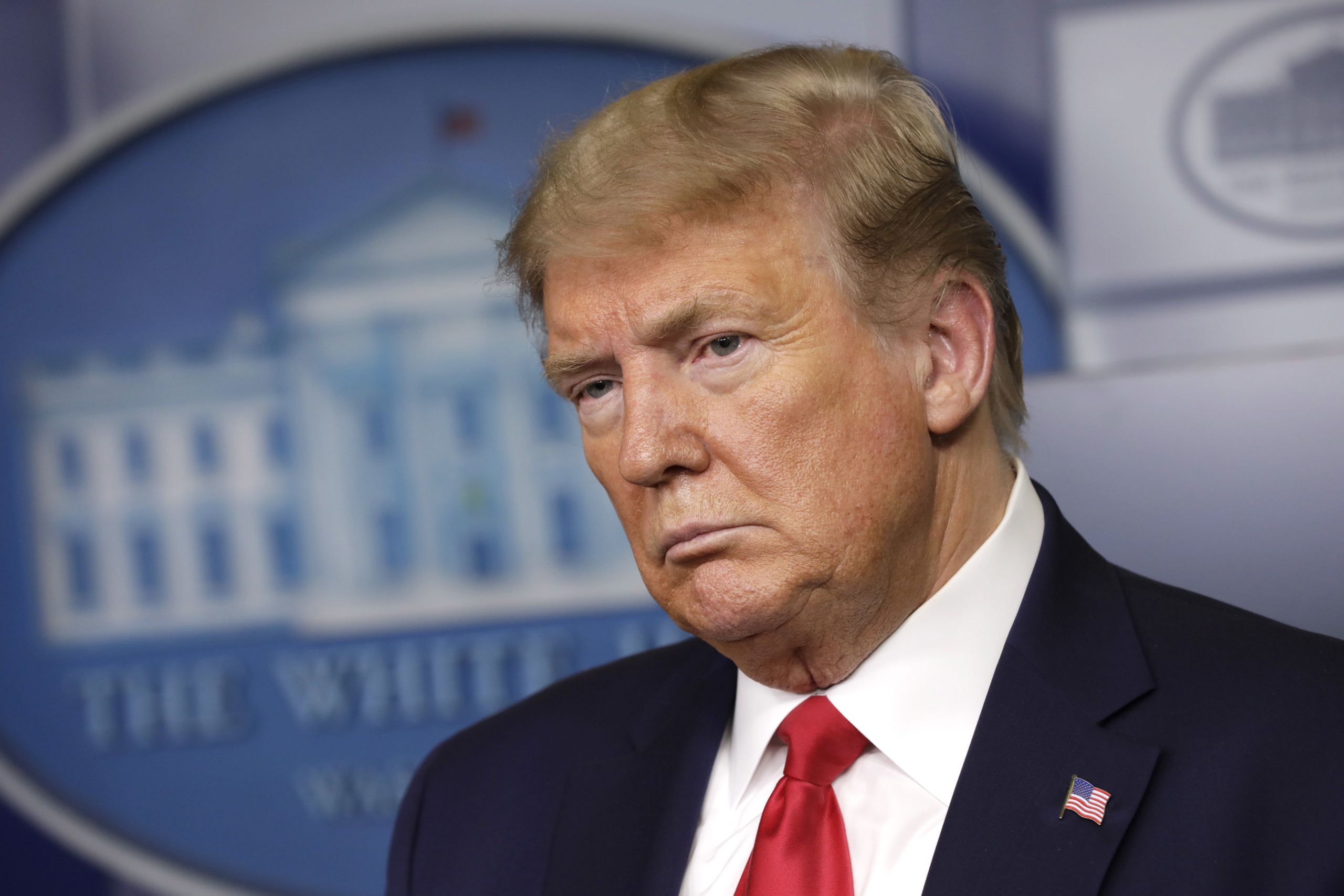 Foto von Donald Trump mit ausdruckslosem Gesicht.