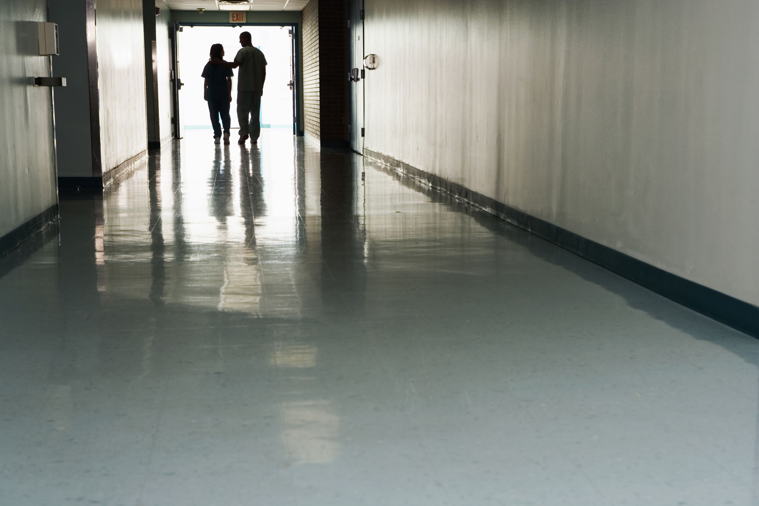 Zwei Menschen stehen am Ende des Korridors im Krankenhaus – Stockfoto