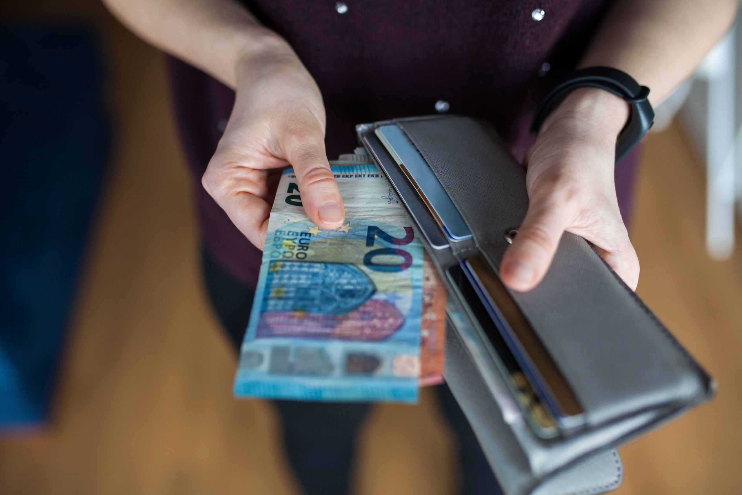 Frau, die Geld aus der Brieftasche zieht