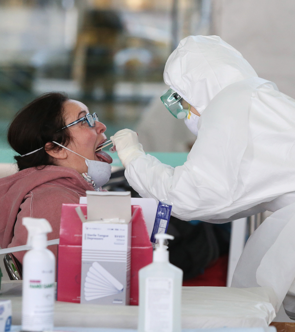 Einer Frau wird eine Rachenprobe entnommen.