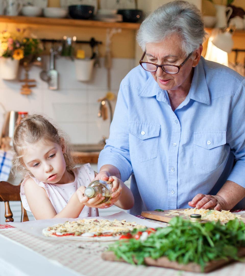 Großmutter kocht mit Enkelkind in einer Küche