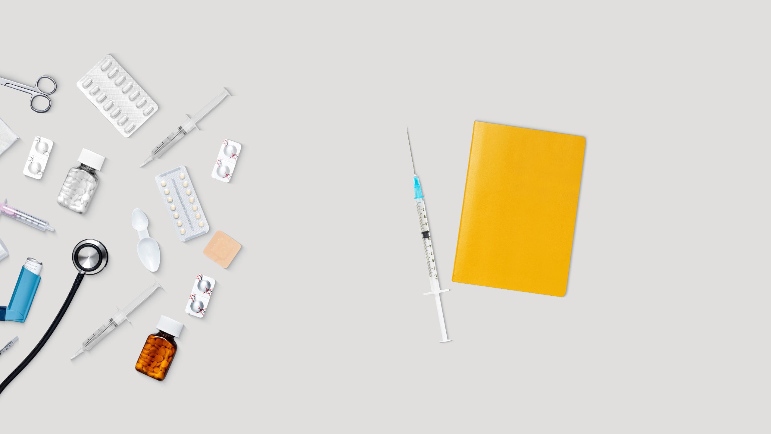 Impfpass, Spritze und Medikamente liegen auf einem Schreibtisch